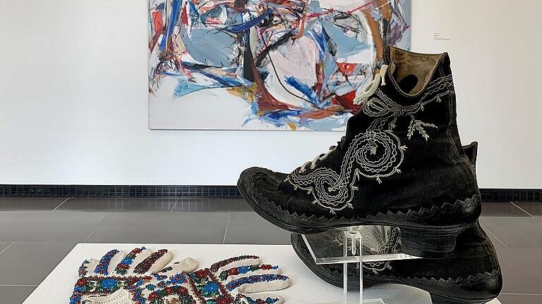 Handschuhe und Stiefel einer historischen Festtagstracht aus dem Ochsenfurter Gau aus dem Museum in der Barockscheune in Volkach in ihrer neuen Umgebung im Nordflügel der Kunsthalle.