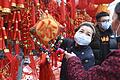 Menschen auf einem Markt in Fuyang in der zentralchinesischen Provinz Anhui tragen Mundschutz, während sie Dekoration für das Neujahrsfest kaufen.