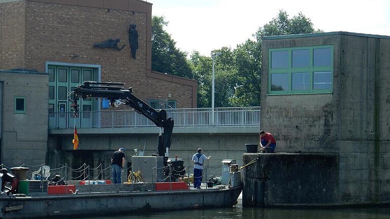 Bauarbeiten an der Schweinfurter Staustufe - (la) Mit Hilfe einer schwimmenden Arbeitsplattform und eines Schiffs der Strompolizei setzte ein Trupp des Wasserstraßen- und Schifffahrtsamtes am Dienstag neue Poller zum Festmachen der Arbeitsboote im Bereich der Schweinfurter Staustufe. Gebraucht werden die kurzen Metallpoller vor allem nach einem Hochwasser, wenn Treibholz eingesammelt wird. Bauarbeiten an der Schweinfurter Staustufe - (la) Mit Hilfe einer schwimmenden Arbeitsplattform und eines Schiffs der Strompolizei setzte ein Trupp des Wasserstraßen- und Schifffahrtsamtes am Dienstag neue Poller zum Festmachen der Arbeitsboote im Bereich der Schweinfurter Staustufe. Gebraucht werden die kurzen Metallpoller vor allem nach einem Hochwasser, wenn Treibholz eingesammelt wird.