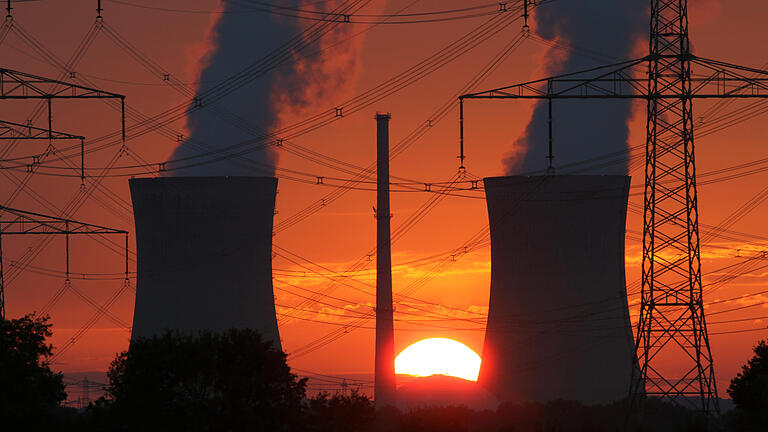 Atomkraftwerk Grafenrheinfeld       -  ARCHIV - Glühend rot ist der Himmel beim Sonnenuntergang am 21.08.2011 hinter den Kühltürmen des Atomkraftwerks Grafenrheinfeld (Bayern). Das Atomkraftwerk wird nach 33 Jahren im Juni 2015 endgültig vom Netz gehen. Foto: Daniel Karmann/dpa (zu dpa 'Pleite für die Atomkonzerne ' vom 04.06.2015) +++(c) dpa - Bildfunk+++ | Verwendung weltweit