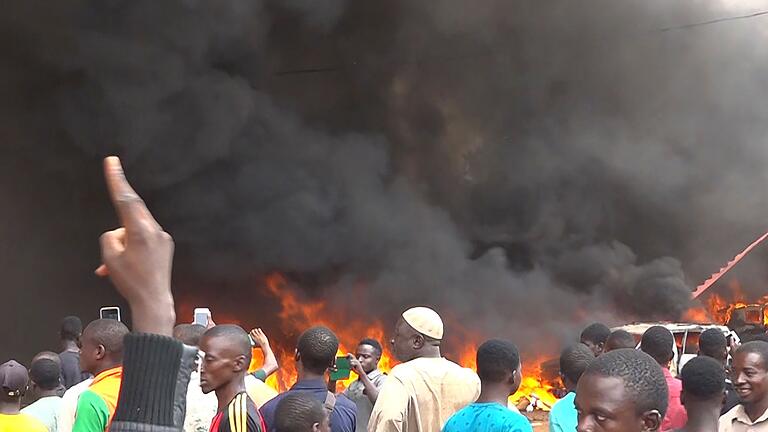 Staatsstreich.jpeg       -  Anhänger meuternder Soldaten sind auf den Straßen von Nigers Hauptstadt Niamey unterwegs, das Hauptquartier der Regierungspartei steht in Flammen. Das Militär hat erklärt, die Forderung der Putschisten nach einem Ende der Amtszeit von Präsident Bazoum zu unterstützen.