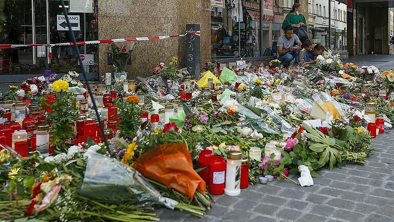 Ein Blumen- und Kerzenmeer erinnert auch am Montag am Würzburger Barbarossaplatz an die Messerattacke vom Freitag.