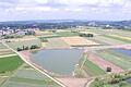 Baggersee bei Sand       -  Im Vordergrund die aktuellen Baggerseen nordöstlich von Sand. In der rechten Bildhälfte oberhalb der offenen Wasserflächen soll das neue Sand- und Kiesabbaugebiet entstehen. Etwa dort, wo der von links nach rechts durch die Bildmitte und entlang der Wasserflächen läuft, ist ein Hochwasserdamm geplant.