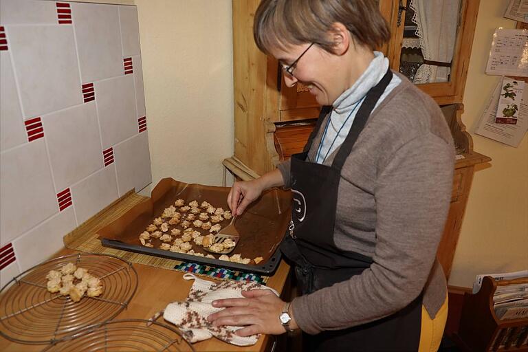 Schwester Juliana hebt die gebackenen Plätzchen vom Blech herunter.