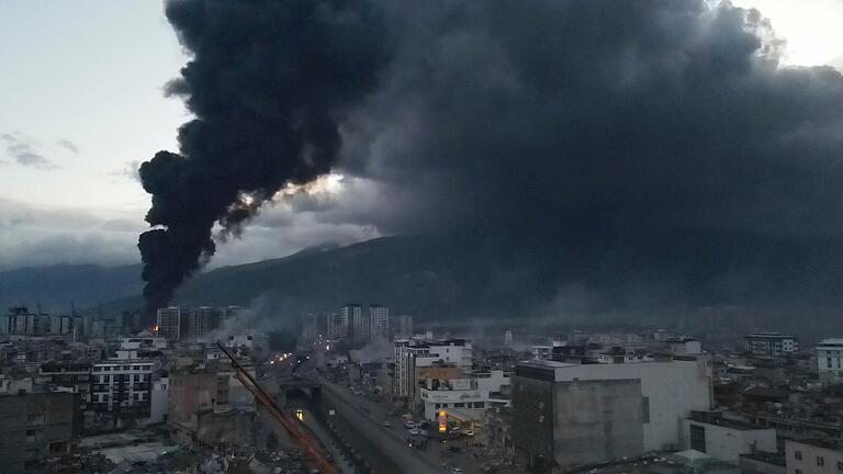Dichter schwarzen Rauch steigt auf aus brennenden Containern im Hafen von Iskenderun in der Türkei. Berichten zufolge wurde das Feuer von Containern verursacht, die während des starken Erdbebens umgestürzt waren. Dichter schwarzen Rauch steigt auf aus brennenden Containern im Hafen von Iskenderun in der Türkei. Berichten zufolge wurde das Feuer von Containern verursacht, die während des starken Erdbebens umgestürzt waren.