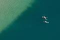 Badegäste schwimmen in einem See. Foto: Armin Weigel       -  Italien glänzt nicht nur bei Badegästen mit seinen Seen.