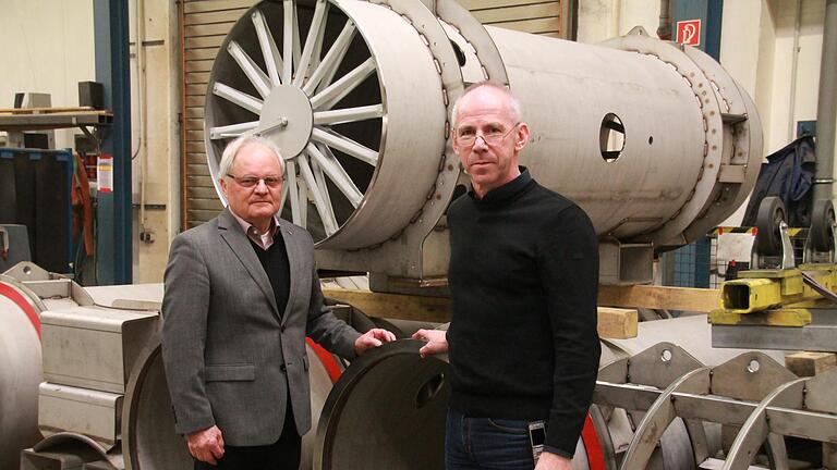 Firmengründer Wilhelm Stöhr (links) und Vorstand Dr. Bernd Völker in einer Halle der MSA AG Karlstadt. Die röhrenförmigen Bauteile sind Elemente für einen Teilchenbeschleuniger.