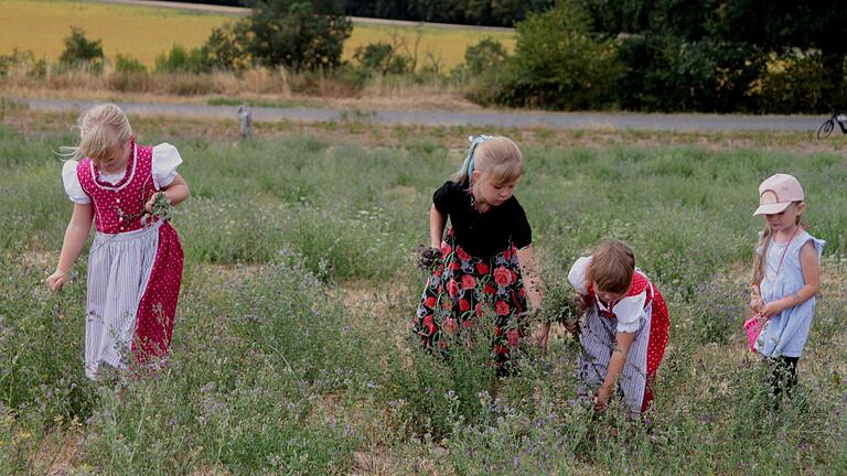 Am Rande der Veranstaltung sammelten Kindern in ihren schmucken Kostümen weitere Blumen und Kräuter.