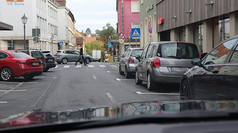 Die Einbahnstraße vor dem ehemaligen Kaufhaus Storg in Kitzingen ist durch beidseitig parkende Autos eng und unübersichtlich.