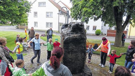 (huGO-ID: 25114557) Sonnenstrahltanz um den Brunnen von Oberspiesheim: Kinder und Erwachsene tanzen gemeinsam um den Brunnen von Oberspiesheim FOTO Erhard Scholl