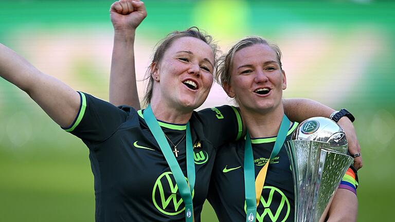 Marina Hegering (l) und Alexandra Popp.jpeg       -  «Das ist mein Baby»: Die Wolfsburgerin Alexandra Popp (r) jubelt mit dem Pokal und ihrer Teamkollegin Marina Hegering.