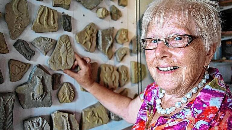 Lügensteine       -  Carola Kleindienst mit Nachbildungen der Eibelstädter Lügensteine im Trias-Museum an der Ochsenfurt.