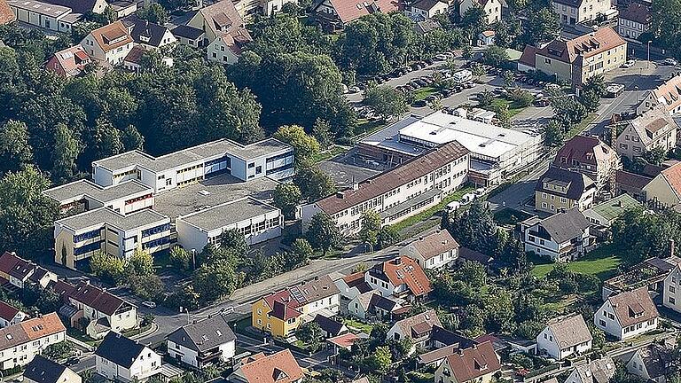 Einen guten Überblick über die Situation auf dem Schulgelände am Lülsfelder Weg vermittelt diese Luftaufnahme aus dem Jahr 2009. Seinerzeit entstand gerade die neue Turnhalle im Osten. Zu sehen sind auf dem Bild die wagenburgartig angelegten Betonklötze der Mittelschule mit der kleinen Turnhalle im Vordergrund und das vorgelagerte Grundschulgebäude von 1954 mit der angebauten neuen Turnhalle. Archivfoto: Arnulf Koch