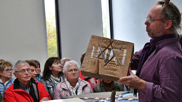 Der Künstler Gernot Ehrsam hatte einen Holzblock mitgebracht, den er künstlerisch gestaltet hatte. Man erkennt den Davidstern und die Inschrift INRI, wie sie am Kreuz Christi angebracht war.