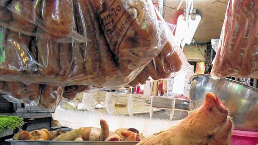 Ein glückliches Schwein? Ein scheinbar fröhlich grinsender Schweinekopf auf einem Markt. Alles wird verwertete in Thailand.