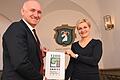 Organisations-Chefin Annette Barreca und Bürgermeister Helmut Krämer mit dem Logo, mit dem sich Giebelstadt im Jubiläumsjahr präsentiert.&nbsp;