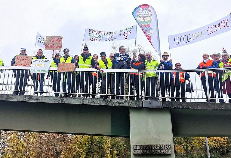 VCC-Getreue mit Sitzungspräsident Manuel Seemann an der Spitze demonstrierten am 11.11. um 11.11 Uhr für den Erhalt des 57 Jahre alten Ludwig-Volk-Stegs. Um ihrer Forderung Nachdruck zu verleihen, banden sie Bürgermeister Jürgen Götz an das Steggeländer.