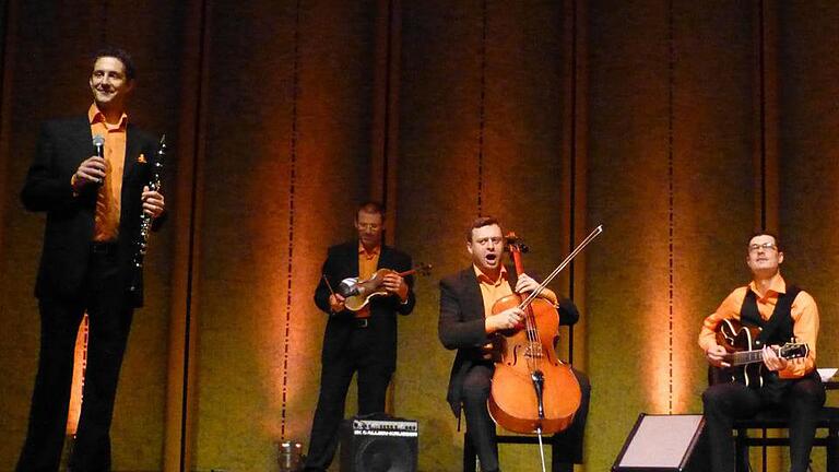 Ein singender Cellist (Eugen Bazijan), ein Klarinettist am Mikro (Alexander von Hagke), ein sinnender Gitarrist (Alex Jung) und ein im Hintergrund träumender Geiger (Sergey Didorenko) leiten das Publikum zum Mitsingen an bei Johann Pachelbels berühmtem Kanon. Foto: Ahnert       -  Ein singender Cellist (Eugen Bazijan), ein Klarinettist am Mikro (Alexander von Hagke), ein sinnender Gitarrist (Alex Jung) und ein im Hintergrund träumender Geiger (Sergey Didorenko) leiten das Publikum zum Mitsingen an bei Johann Pachelbels berühmtem Kanon. Foto: Ahnert