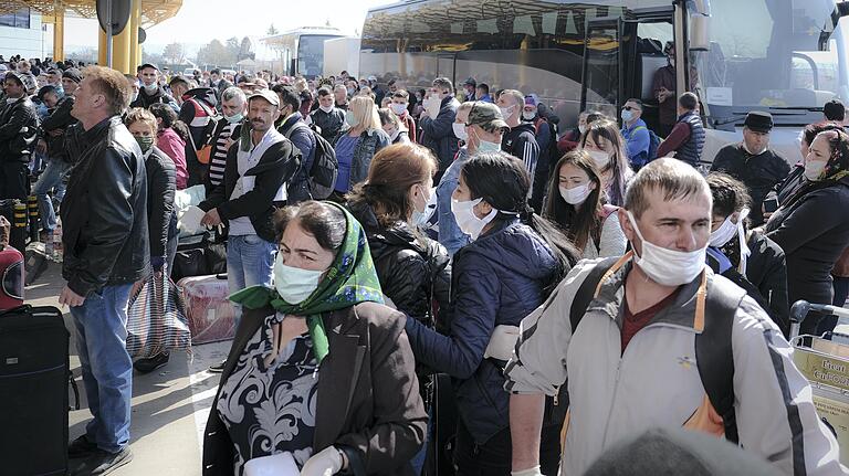 Saisonarbeiter mit Mundschutz warten im rumänischen Cluj-Napoca vor dem Flughafen Avram Iancu. Mit strengen Sicherheitsvorgaben dürfen 80 000 Saisonarbeiter nach Deutschland kommen.&nbsp;