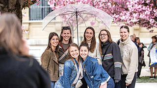 Einige Menschen tummeln sich am Sonntag (13.04.25) im Hofgarten der Residenz in Würzburg. Die Kirschblüte lockt jedes Jahr im April viele Besucher in die Gartenanlage.