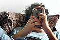 iPhone-Nutzung       -  Symbolbild: Jugendlicher mit Smartphone