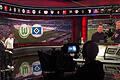 Lothar Matthäus und Moderator Sebastian Hellmann (von links) moderieren den &bdquo;Super-Samstag&ldquo; an. Die Experten Reiner Calmund und Christoph Metzelder warten auf ihren Einsatz, während der Kameramann im Vordergrund und viele andere Mitarbeiter im Studio A jeden Samstag acht Stunden unter Hochspannung arbeiten.