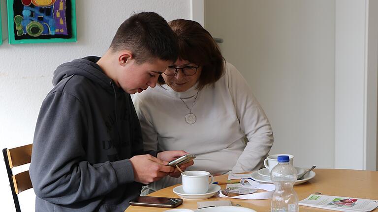 Ben Kunitzty (links) erklärt Gerlinde Stumpf den Unterschied zwischen WhatsApp-Profilbild und WhatsApp-Status bei einer Tasse Kaffee und einem Stück Kuchen. Ben Kunitzty (links) erklärt Gerlinde Stumpf den Unterschied zwischen WhatsApp-Profilbild und WhatsApp-Status bei einer Tasse Kaffee und einem Stück Kuchen. 