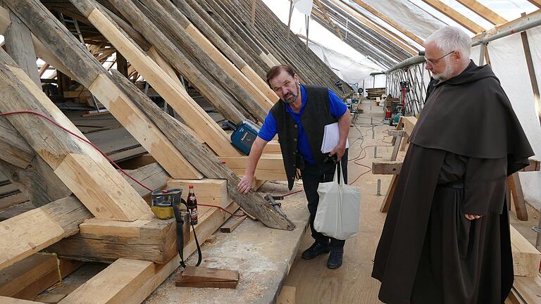 Diplom-Ingenieur Anton Landgraf und Prior Klemens August Droste begutachten die Arbeitsfortschritte im Dachstuhl der Karmelitenkirche.