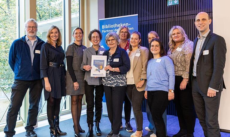 Staatsministerin Anna Stolz (zweite von links), Bürgermeisterin Judith Roth-Jörg (dritte von links) und Kulturreferent Benedikt Stegmayer (erster von rechts) freuen sich gemeinsam mit Martha Maucher (vierte von links), Leiterin der Stadtbücherei, Angelika Riedel (fünfte von links), Leiterin der Kinderbücherei und weiteren Teammitgliedern über die Auszeichnung. Staatsministerin Anna Stolz (zweite von links), Bürgermeisterin Judith Roth-Jörg (dritte von links) und Kulturreferent Benedikt Stegmayer (erster von rechts) freuen sich gemeinsam mit Martha Maucher (vierte von links), Leiterin der Stadtbücherei, Angelika Riedel (fünfte von links), Leiterin der Kinderbücherei und weiteren Teammitgliedern über die Auszeichnung.