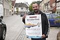 Werbering-Vorsitzender Rene Tierno mit einem Plakat des 1. Hofheimer Straßenfests, das in diesem Jahr Premiere feiert und am 19. und 20. August in der Hauptstraße und der Grünen Marktstraße stattfindet.