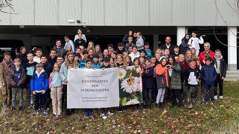 Die Schüler der Mittelschule Höchberg entrollen ihr Banner für den künftigen Bienengarten der zehn Jahreszeiten.