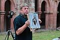 Fledermausfachberater Uwe Scheurich zeigt an einem Schaubild den anatomischen Aufbau einer Fledermaus. Im Hintergrund ist sein Batrecorder zu sehen, mit dem man die Töne der Tiere für den Menschen hörbar machen kann.