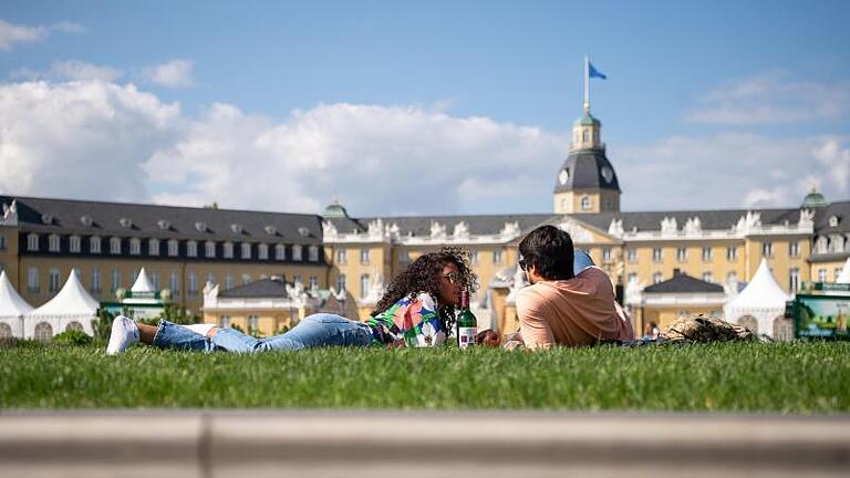 Paar auf Wiese vor dem Schloss in Karlsruhe.jpeg       -  Karlsruhe hat zwei neue Städtepartnerschaften hinzubekommen.