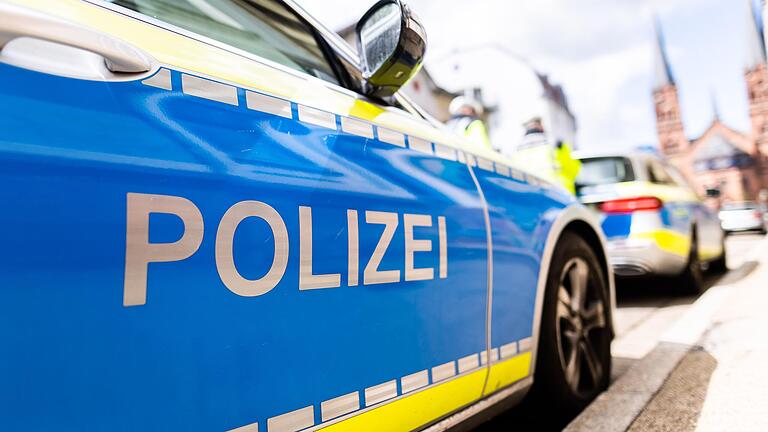 Zwei Einsatzfahrzeuge der Polizei stehen am Straßenrand. (Symbolbild)