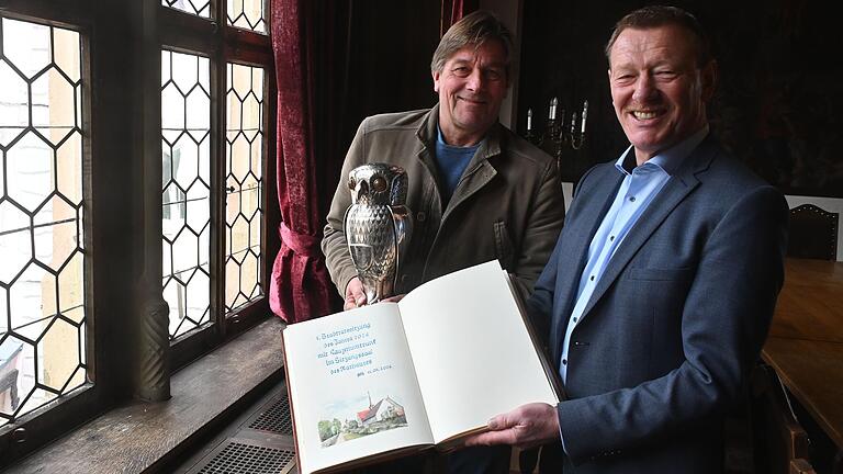 Heiner von Zobel und Bürgermeister Peter Juks mit dem Kauzenpokal und dem Kauzenbuch, dessen Seiten zur diesjährigen Kauzensitzung noch leer sind. Heiner von Zobel und Bürgermeister Peter Juks mit dem Kauzenpokal und dem Kauzenbuch, dessen Seiten zur diesjährigen Kauzensitzung noch leer sind.