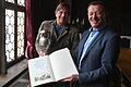 Heiner von Zobel und Bürgermeister Peter Juks mit dem Kauzenpokal und dem Kauzenbuch, dessen Seiten zur diesjährigen Kauzensitzung noch leer sind.