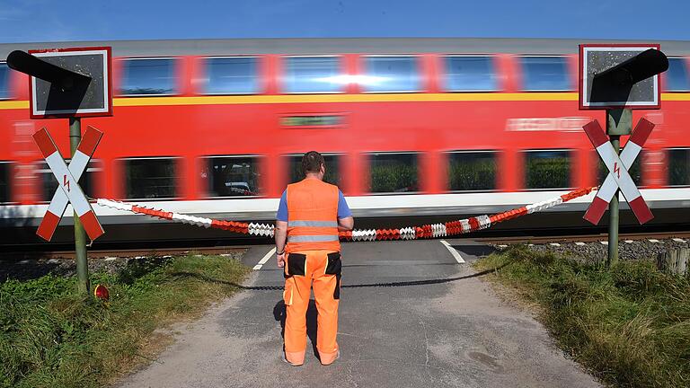 Ein Mitarbeiter einer Sicherheitsfirma an einem gesicherten Bahnübergang.&nbsp;