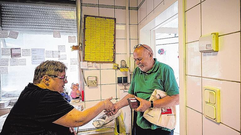 Stammkunde Fritz Schröter (rechts) kauft bei Inge Dittmar in der Schweinfurter Fischhandlung Dittmar eine Makrele.