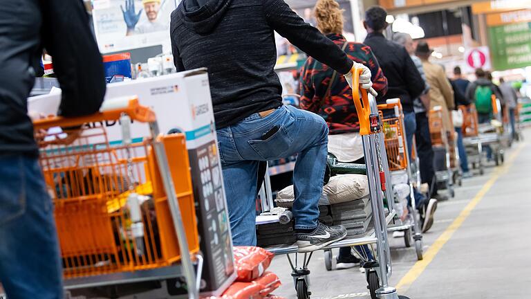 Das war einmal: Kunden stehen mit Einkaufswagen in einem Baumarkt in einer Schlange vor den Kassen an. Die Corona-Krise könnte den Bau- und Gartenfachmärkten in Deutschland einen regelrechten Nachfrageboom durch kurzarbeitende Heimwerker bescheren - wenn eben nicht der Lockdown wäre.