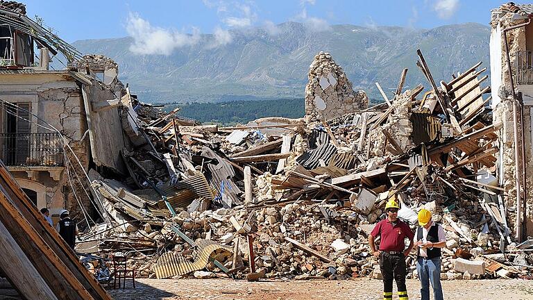 Die Abruzzen - Erdbebenregion in Mittelitalien       -  Nach dem Beben im April 2009: Helfer stehen in dem stark zerstörten Dorf Onna nahe der italienischen Stadt L'Aquila.