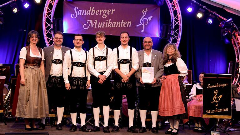 Feierstunde für die drei jüngsten Musiker der Sandberger Musikanten. Sie wurden für zehn Jahre Mitgliedschaft mit der Ehrennadel in Bronze von Renate Haag, der Kreisvorsitzenden des Nordbayerischen Musikbundes, ausgezeichnet. Dominik Söder wurde mit Silber für 20 Jahre geehrt. Auf dem Foto von links Renate Haag, Fabian Friedel, Fabian Söder, Paul Söder, Noah Bühner, Dominik Söder, Alexandra Hourle.