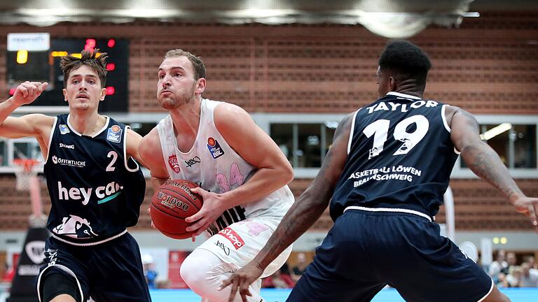 Basketball - Bosch Rexroth Cup - s.Oliver Wuerzburg - BB Loewen Braunschweig       -  Würzburgs Felix Hofmann (Mitte) setzt sich im Vorbereitungsturnier gegen Dennis Nawrocki (links) und Travis Taylor von den Basketball Löwen Braunschweig durch.