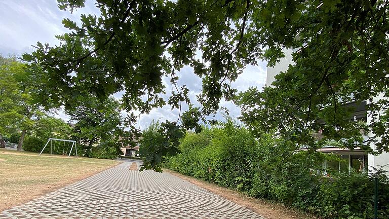 Nachbarinnen und Nachbarn befürchten, dass sich spielende Kinder an den Betonsteinen der Feuerwehrzufahrt verletzen könnten. Sie fordern, dass der Bereich vom Spielplatzgelände durch eine Hecke oder einen Zaun abgetrennt wird.