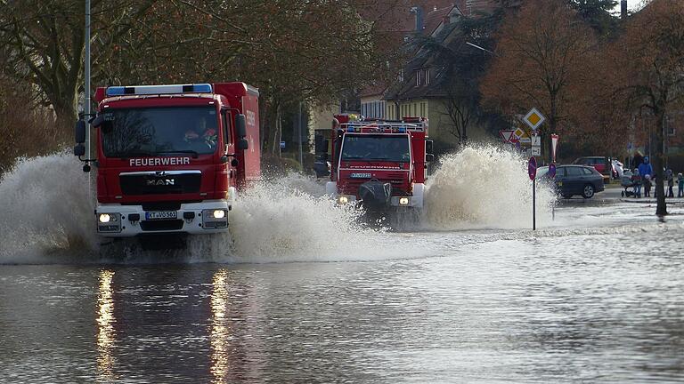 Auch im Ortsbreich von Volkach gab es gesperrte Straßen wegen Hochwasser. Zwei Feuerwehrautos üben das sichere Durchqueren der überfluteten Straße.