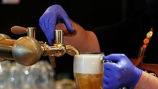 Ein Bier wird gezapft       -  Ein Barkeeper zapft ein Bier auf einer Restaurant-Terrasse. (Symbolbild)
