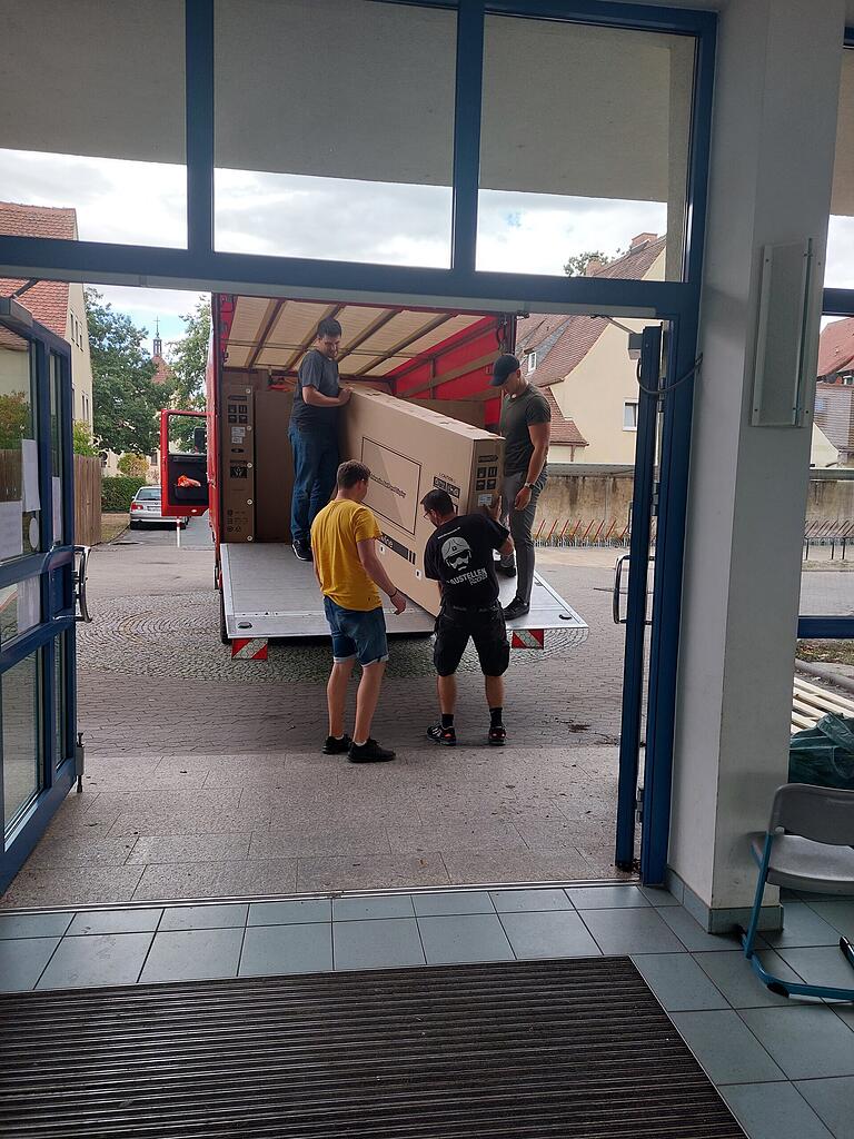 Stadtverwaltung und Feuerwehr packten gemeinsam beim Ausladen der digitalen Tafel vor der Grundschule Siedlung an. Stadtverwaltung und Feuerwehr packten gemeinsam beim Ausladen der digitalen Tafel vor der Grundschule Siedlung an.