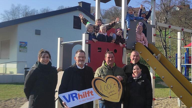 Auf dem Spielplatz (von links): Arbeitskreismitglied Andrea Zehe, Spendenbotschafter der VR-Bank Rhön-Grabfeld Peter Suckfüll, Ortsbeauftragter und Arbeitskreismitglied Dirk Zehe, Arbeitskreismitglied und Gemeinderat Christian Holzheimer, Arbeitskreismitglied Sandra Metz, im Hintergrund Kinder aus Schmalwasser.