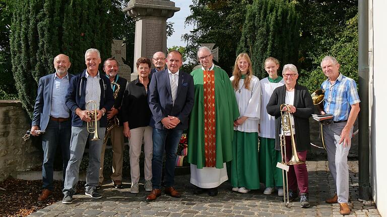 Nach dem Friedensgottesdienst und der Kranzniederlegung mit beeindruckenden Reden am Kriegerdenkmal in Burggrumbach. Mit dabei waren die 2. Vorsitzende und der 1. Vorsitzende des Kulturgeschichtlichen Arbeitskreises Reinhilde Schraud und Günter Dusel, Bürgermeister Alois Fischer, Pfarrer Helmut Rügamer (4. bis 6. von links) sowie Musikanten und Ministrantinnen aktiv.