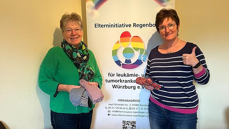 Hilde Oppmann und Denise Lampert (Elterninitiative Regenbogen) bei der Übergabe der Socken (von links).