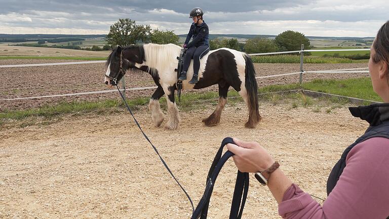 Auf Irish Tinker 'Guinness' dreht die 11-jährige Hannah unter Anleitung von Reittherapeutin Anna Drescher ihre Runden auf dem Reitplatz in Rottenstein. Das Mädchen hat Trisomie 21.